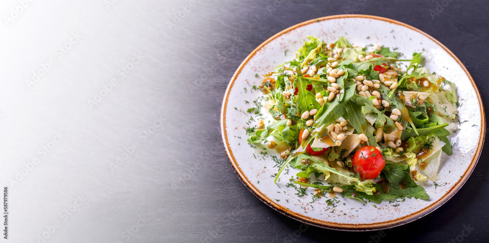Arugula salad with pine nuts, cherry tomatoes and cheese on withe plate. Copy space Arugula salad with pine nuts, cherry tomatoes and cheese on withe plate. Copy space