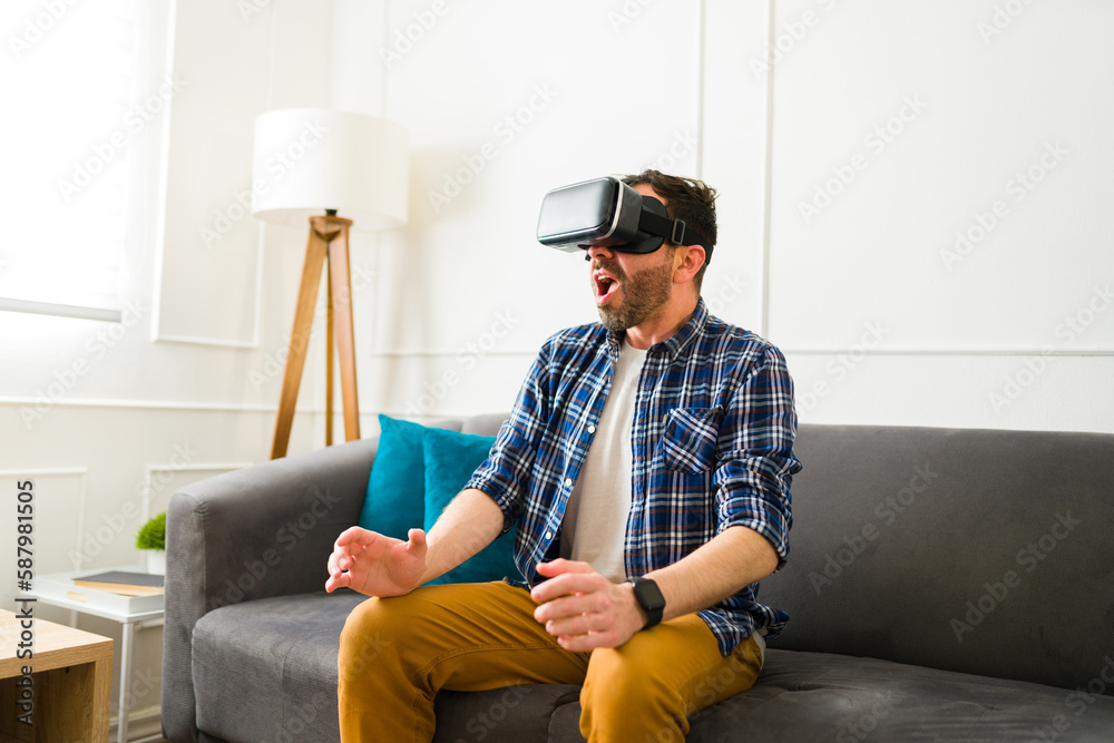 Excited man watching a virtual reality video with glasses