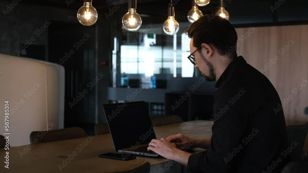 portrait of a businessman working on a laptop in his modern school office portrait of a businessman working on a laptop in his modern school office