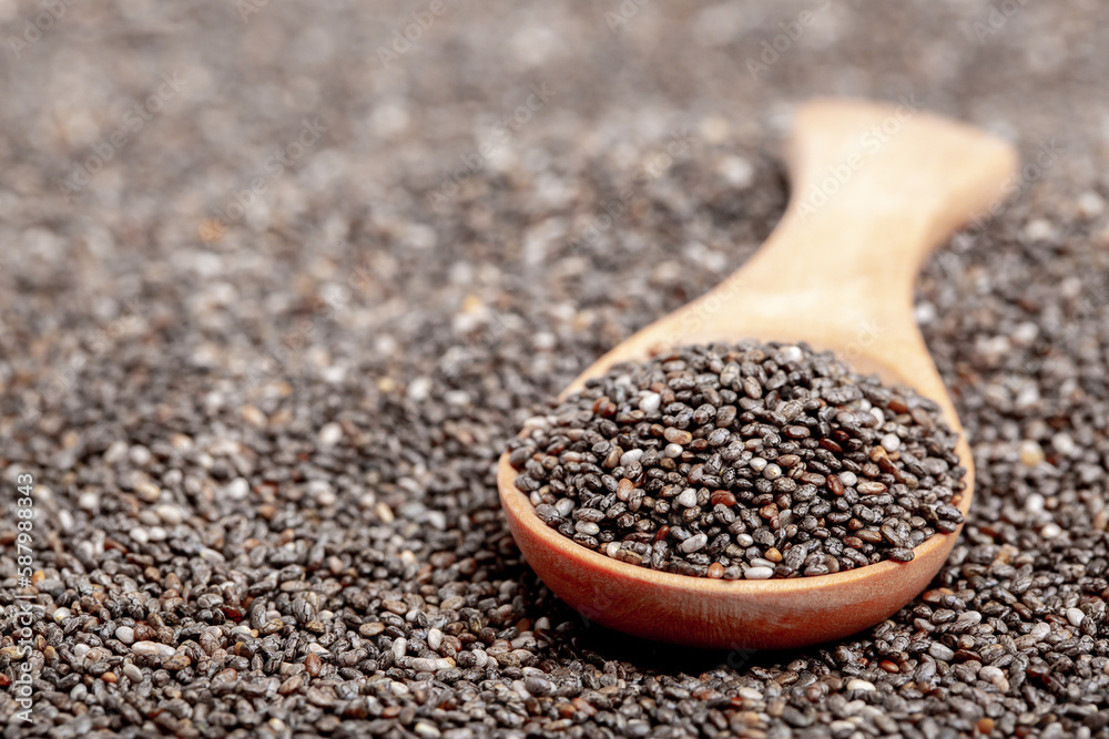 Chia seeds close-up with a wooden spoon. Chia seeds macro. Dry healthy supplement for proper nutrition. Chia seeds close-up with a wooden spoon. Chia seeds macro. Dry healthy supplement for proper nutrition.