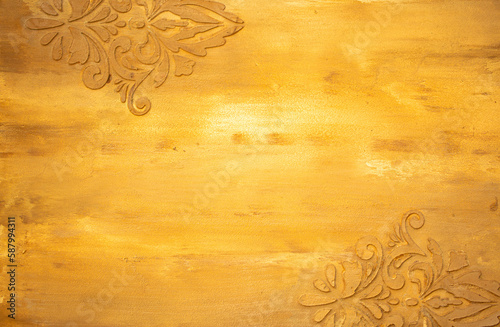 Golden wall with abstract spots as a background. Beautiful golden texture with patterns, decorative plaster. Modern bright wall painting in trendy shades, unusual spotted yellow and gold surface.