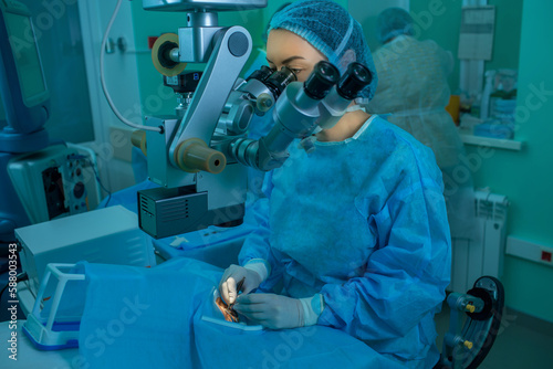 woman ophthalmologist performs an operation on the patient's eye