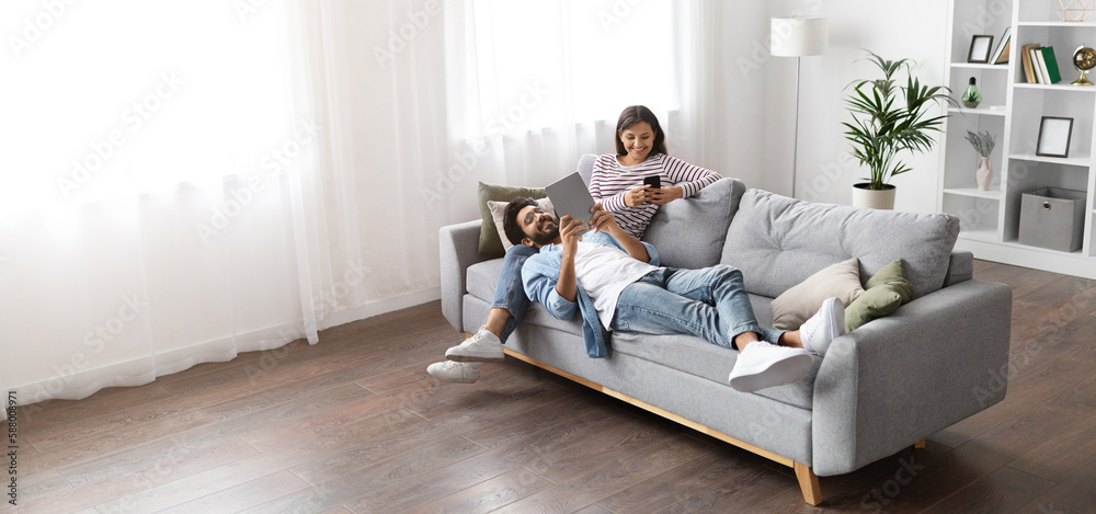 High angle view of multiracial couple relaxing on couch High angle view of multiracial couple relaxing on couch