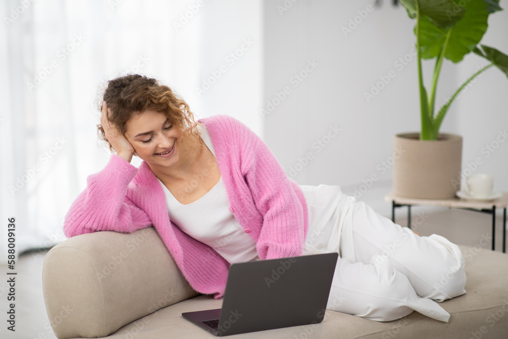 Happy Young Woman Relaxing With Laptop On Couch At Home Happy Young Woman Relaxing With Laptop On Couch At Home
