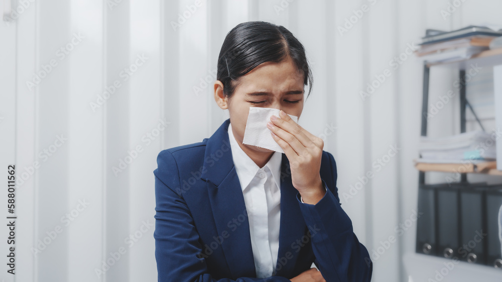 Young pretty asian business woman having covid and sinus in office with sneeze, tissue and runny nose while working on laptop. Young pretty asian business woman having covid and sinus in office with sneeze, tissue and runny nose while working on laptop.