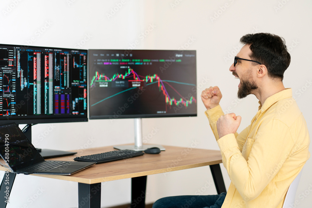 Overjoyed trader earn money, celebration success, looking at rise of crypto chart sitting in modern office, selective focus. Successful business, online trading concept