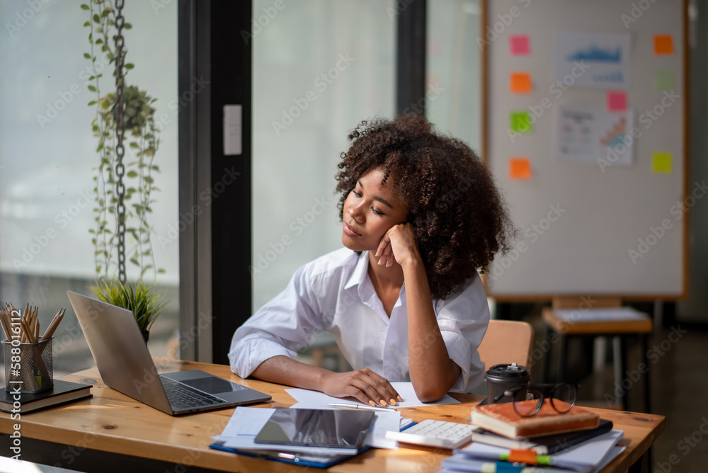 Black woman sitting in front of her considering work, office work Business woman sitting thinking work concept Black woman sitting in front of her considering work, office work Business woman sitting thinking work concept