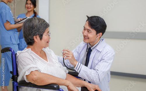 Asian male doctor, professional doctor wearing white coat, help Counseling care for elderly women in the hospital