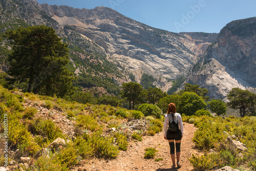 Hiking on Lycian way trail. Young girl with backpack enjoy view of Babadag is a mountain near Fethiye, in Mugla Province, southwest Turkey. 