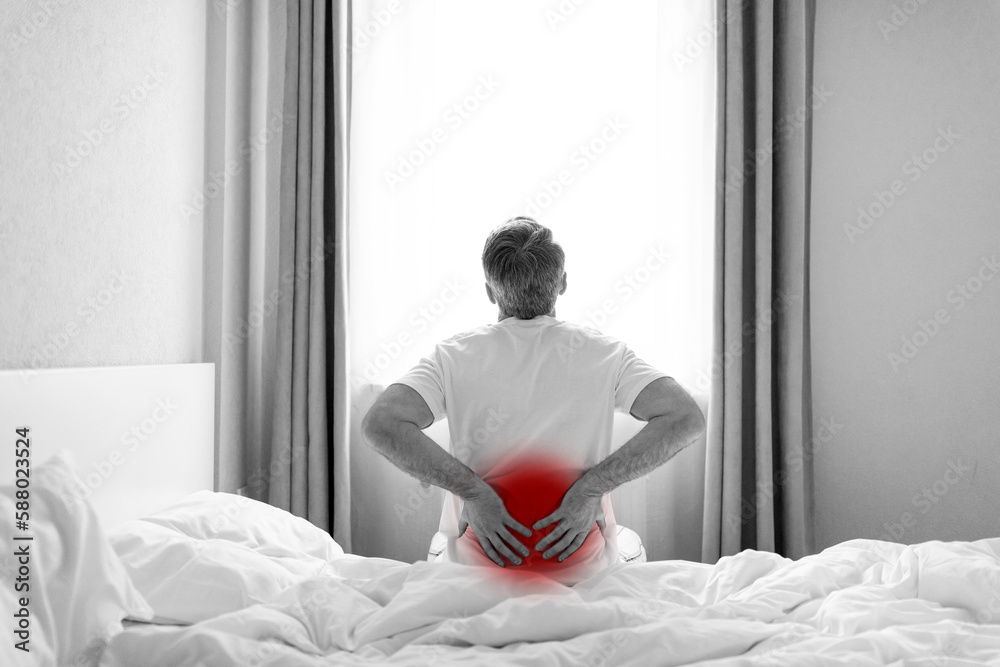 Black and white photo of man suffering from back pain Black and white photo of man suffering from back pain