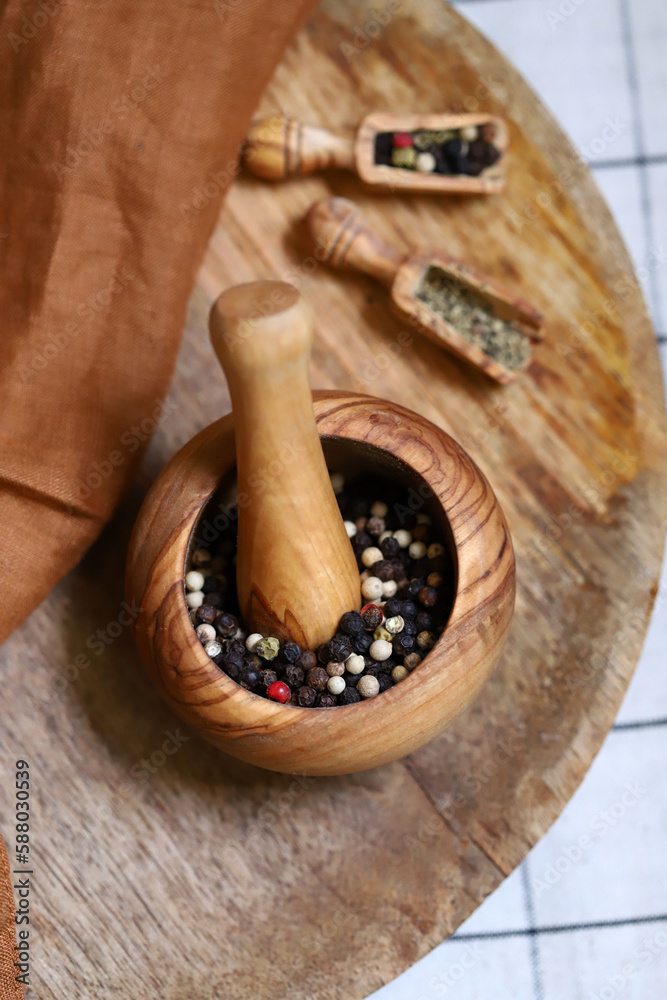Close-up. Mix of peppercorns in a wooden bowl and in wooden spatulas.