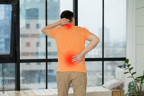 Back pain, man with backache at home photo