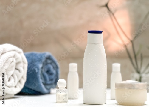 Closeup of toiletries bathroom setup in a isolated white tiles background with copy space for inscription. Towl, dispensers, comb, toothbrush and moisturizer. Bathroom interior. 