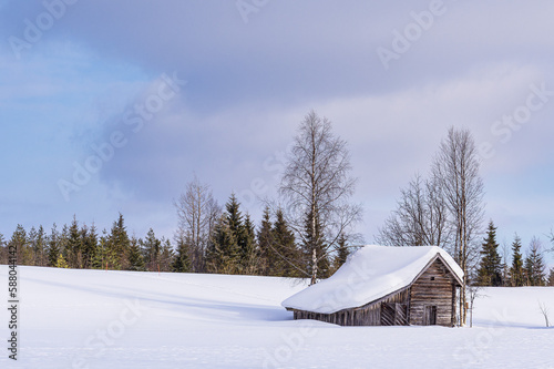 Landschaft mit Schnee und Holzhütte im Winter in Kuusamo, Finnland © Rico Ködder