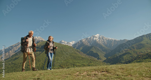 Mature caucasian couple on vacation, having a hike in spring mountains, spending time together after retirement together travelling - tourism, pension concept