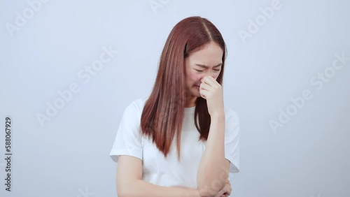 Woman pinching her nose because of bad smell in casual clothes and looks disgusting in white background.