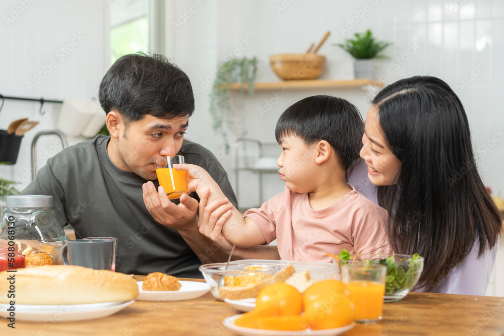 Happy refreshment family breakfast in morning, asian young parent father, mother and little cute boy, child having meal in kitchen eating together at home. Cheerful, enjoy cooking people. Happy refreshment family breakfast in morning, asian young parent father, mother and little cute boy, child having meal in kitchen eating together at home. Cheerful, enjoy cooking people.