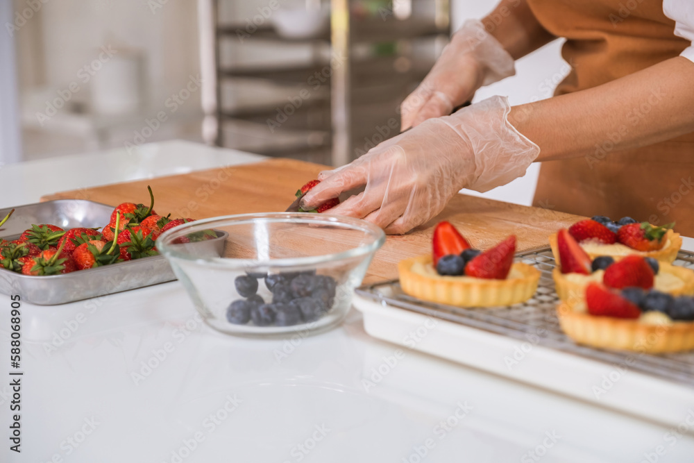 Woman decorating bakery with berries. Woman decorating bakery with berries.