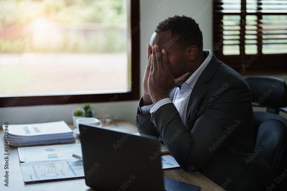 Burnout American African business man in stress works with many paperwork document, migraine attack, Freelance, work from home Burnout American African business man in stress works with many paperwork document, migraine attack, Freelance, work from home