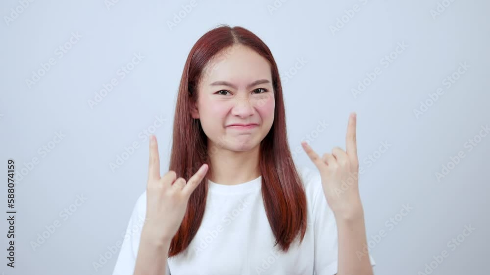 Asian woman showing rocker sign feeling enthusiastic Asian woman showing rocker sign feeling enthusiastic