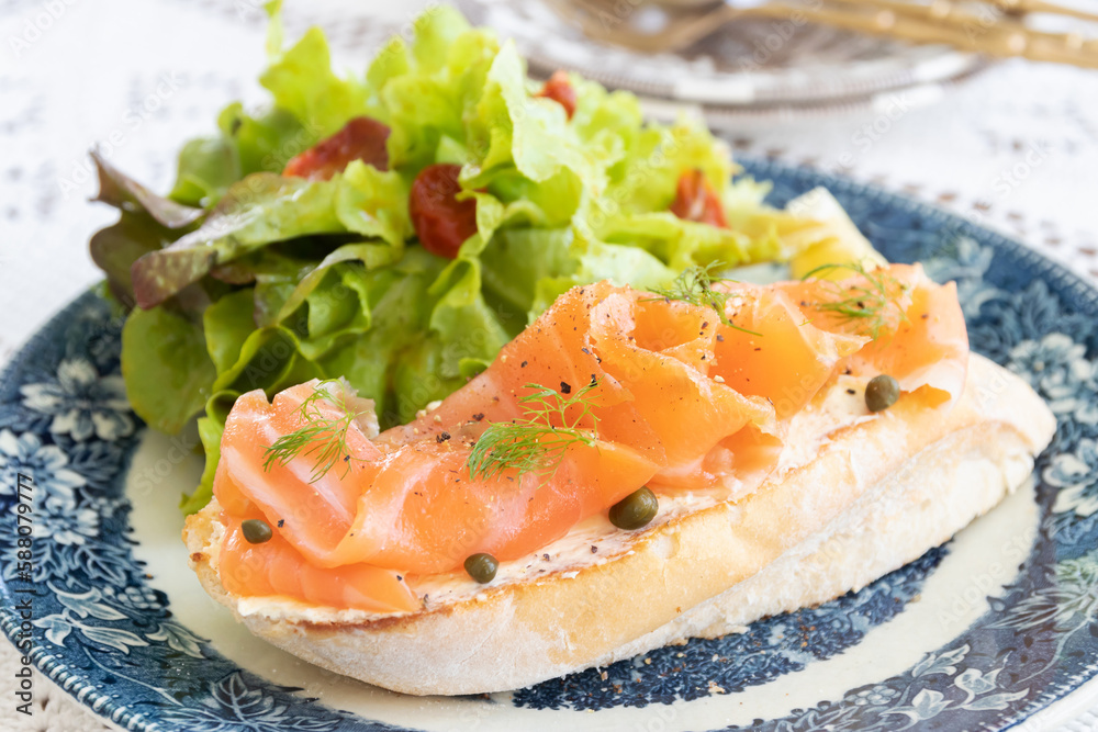 Smoked salmon with cream cheese on french baguette and fresh salad. Smoked salmon with cream cheese on french baguette and fresh salad.