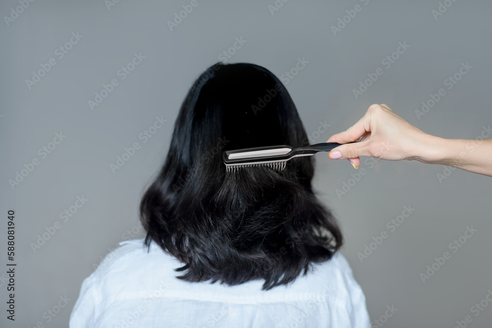 Fototapeta premium close-up hand combing hair with a comb. hairdresser services