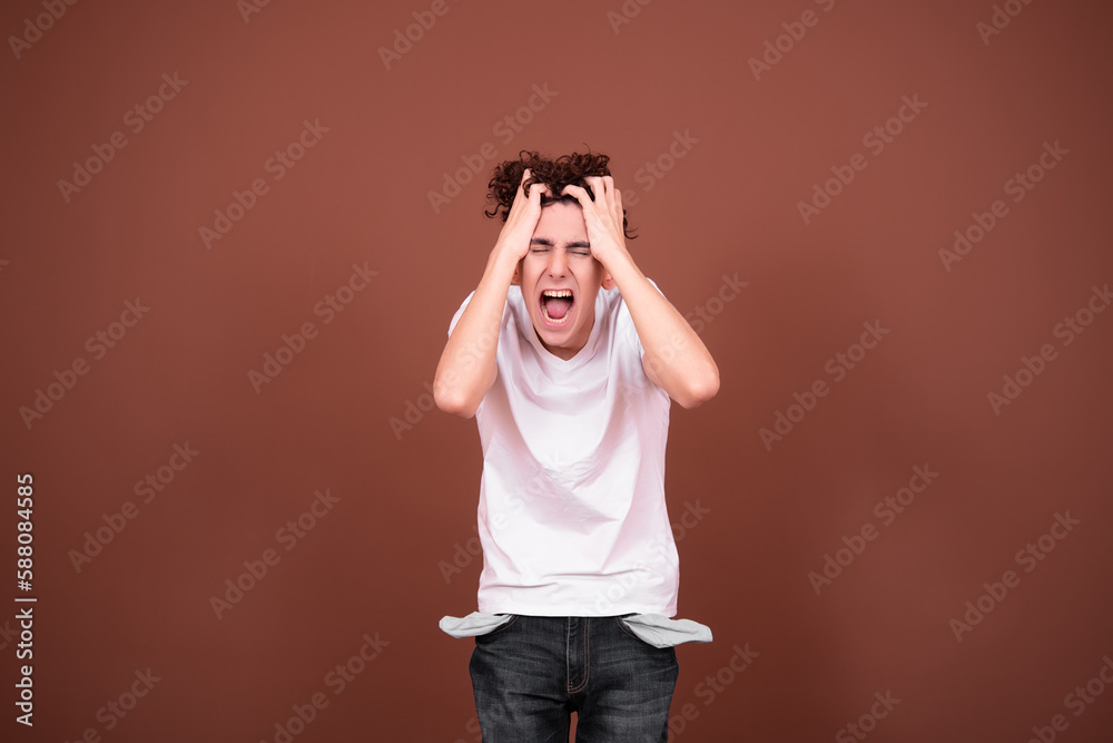 Screaming bankrupt man with empty pockets. Debts and lending. Brown background. Screaming bankrupt man with empty pockets. Debts and lending. Brown background.