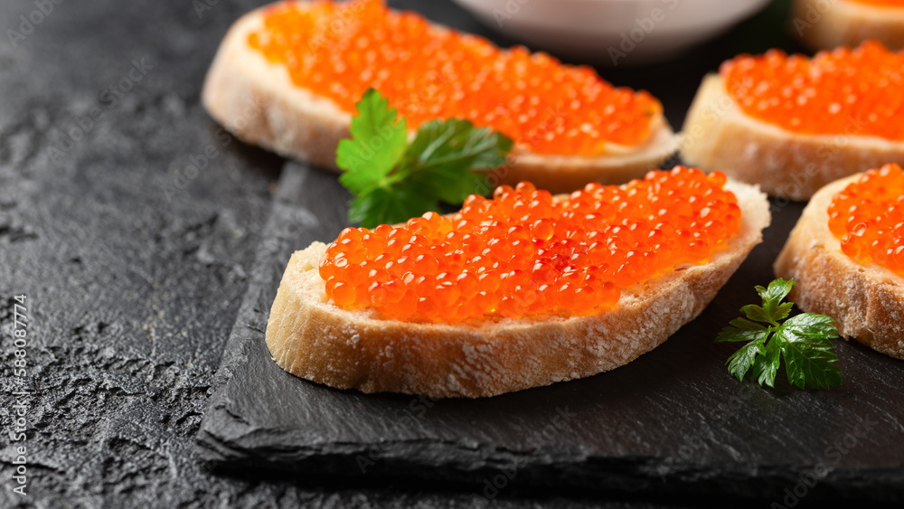 Salmon red caviar sandwiches on rustic stone board Salmon red caviar sandwiches on rustic stone board