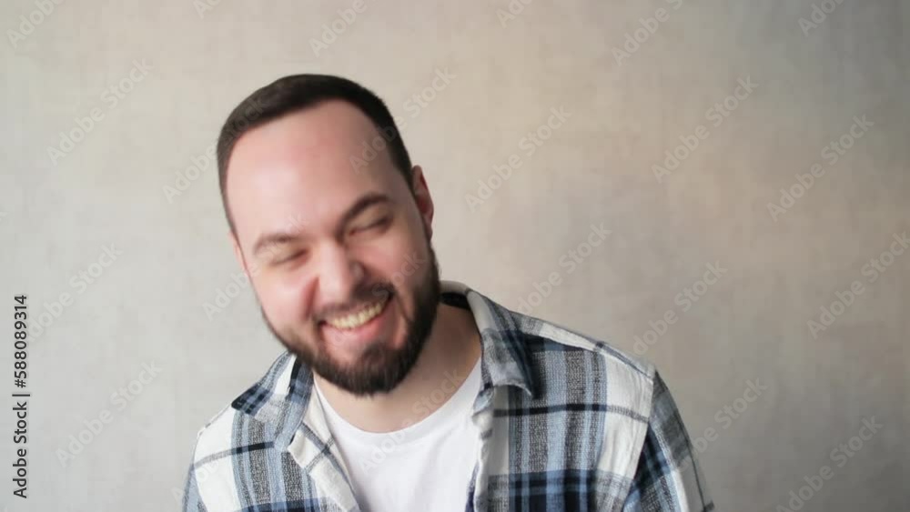 Close up portrait of one handsome happy young man laughing and looking at camera