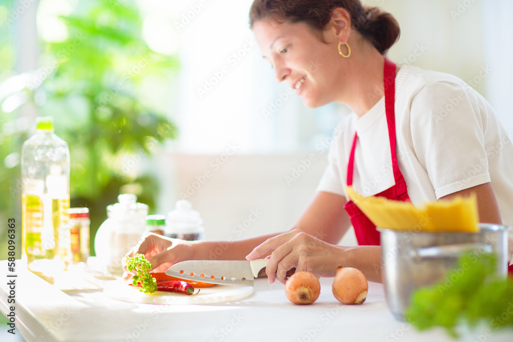 Woman cooking dinner. Cook spaghetti