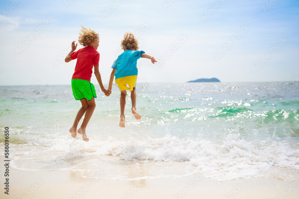 Kids on tropical beach. Children playing at sea.