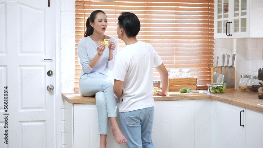 Happy Asian couple, Wife feeds the homemade sweets to the husband to taste. Happy Asian couple, Wife feeds the homemade sweets to the husband to taste.