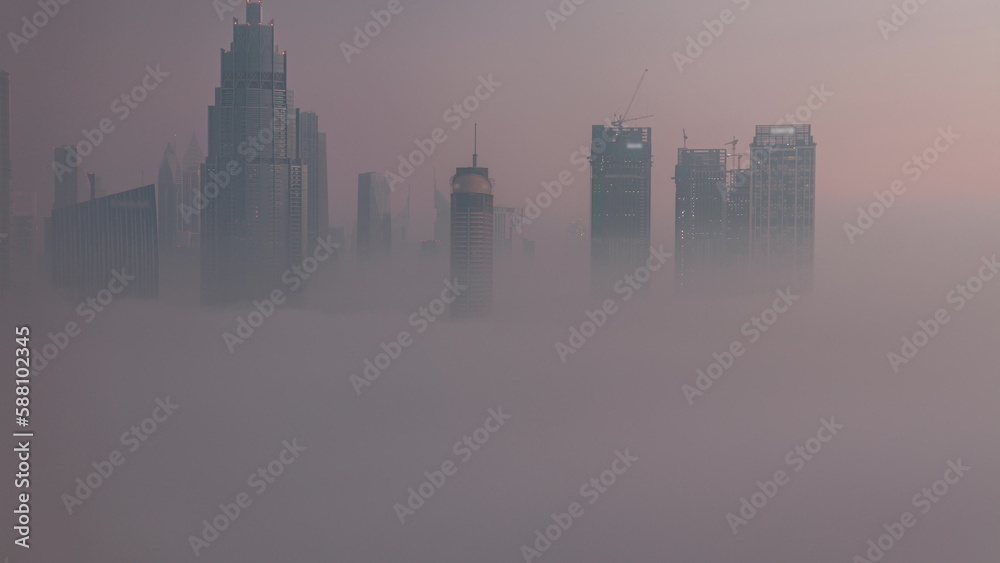 Aerial view morning fog covered Dubai International Financial Centre district night to day timelapse