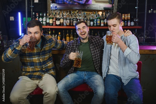 Group of excited friends in beer pub watching sports match