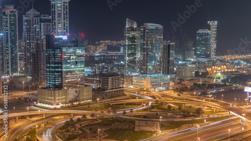 Highway crossroad and office buildings in Dubai Internet City and Media City district aerial night timelapse