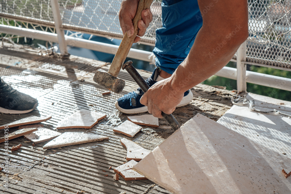 Bricklayer breaking some floor tiles. Working in a construction. Bricklayer breaking some floor tiles. Working in a construction.