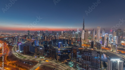 Skyline with modern architecture of Dubai business bay towers day to night timelapse. Aerial view
