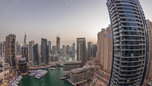 Aerial view to Dubai marina skyscrapers around canal with floating boats day to night timelapse © neiezhmakov