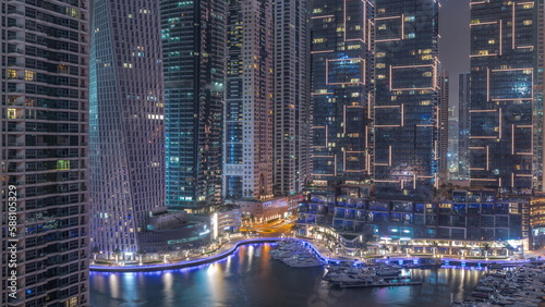 Dubai Marina luxury tourist district with skyscrapers and towers around canal aerial all night timelapse