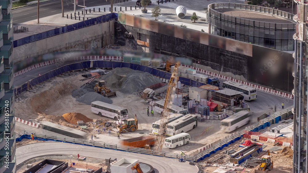 Cranes and bulldozers working at construction site of new skyscraper aerial timelapse.