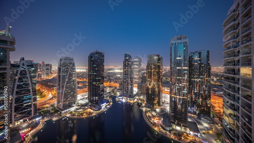 Tall residential buildings at JLT aerial day to night timelapse, part of the Dubai multi commodities centre mixed-use district.