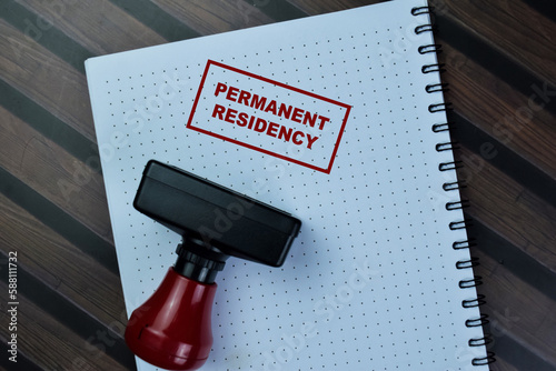 Concept of Red Handle Rubber Stamper and Permanent Residency text isolated on on Wooden Table.