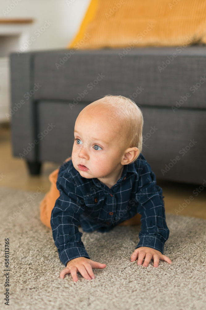 Nursery baby boy crawling on floor indoors at home copy space and empty space for text - Baby curiosity and child development stages Nursery baby boy crawling on floor indoors at home copy space and empty space for text - Baby curiosity and child development stages