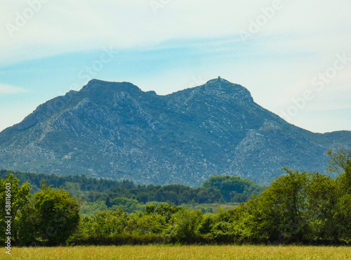 Breathtaking landscape with a meadow and the vegetation of the provencal nature and in the background the majestic Opies mountain in the Alpilles chain in Provence in France photo