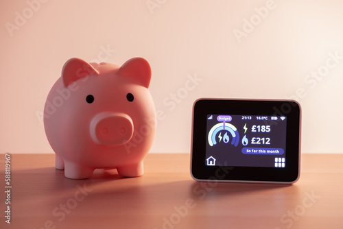 Smart meter, energy meter. Checking domestic electricity and gas use. Smart meter reading over budget. Piggy bank, savings.