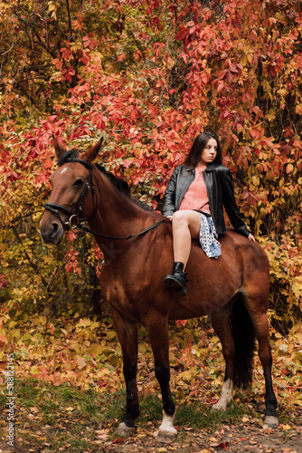 A woman on a horse in the autumn forest. Riding