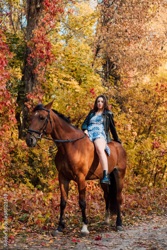 A woman on a horse in the autumn forest. Riding
