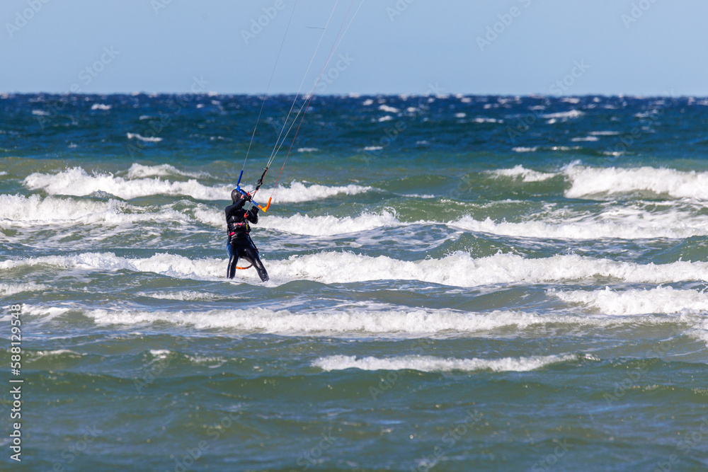 one kitesurfer surfing in stormy weather on the baltic sea