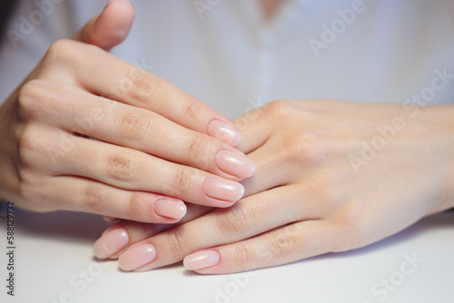 Fototapeta Naklejka Na Ścianę i Meble -  Gentle nude manicure on her nails. Classic bridal nail design.