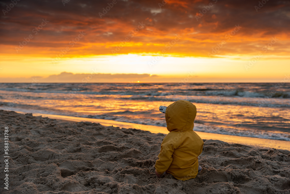 Dziecko oglądające zachód słońca nad Bałtykiem / A child watching the sunset over the Baltic Sea - obrazy, fototapety, plakaty 